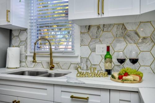 een keuken met een gootsteen, een schaal met fruit en wijnglazen bij Tampa Retreat with Heated In-Ground Pool & Spa in Tampa