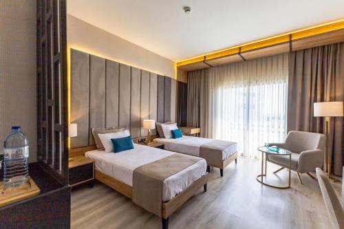 a hotel room with two beds and a chair at Paradisos Hotel in Trakhoni