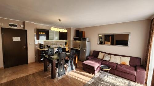 een keuken en woonkamer met een bank en een tafel bij SPOMAR One Bedroom Apartment in Bansko