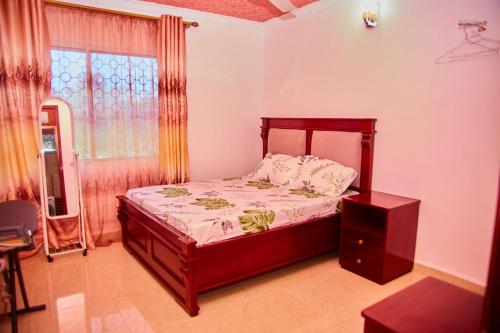 Un dormitorio con una cama y una ventana en Kilimani Apartment 1, en Migombani