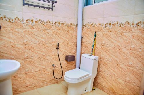 Un baño con inodoro y una pared con arañas. en Kilimani Apartment 1, en Migombani