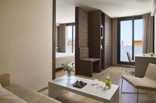 a living room with a couch and a table at NH Castellón Mindoro in Castellón de la Plana