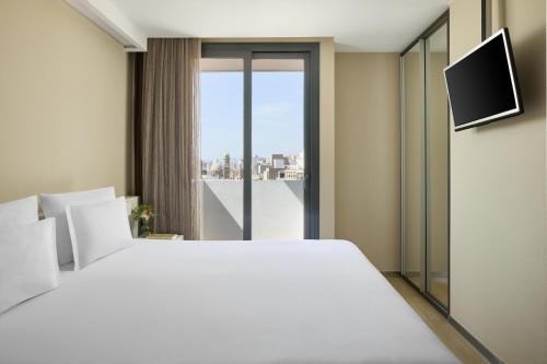 a bedroom with a large white bed and a window at NH Castellón Mindoro in Castellón de la Plana