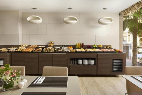 Una cocina con un buffet con comida encima. en NH Castellón Mindoro, en Castellón de la Plana