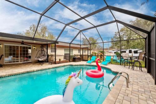 a swimming pool with inflatable animals in a house at Exquisite Retreat with Heated Pool for 14 Guests, Pool Table Paradise! in Brandon