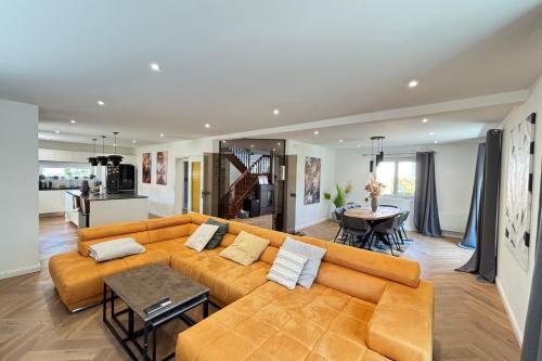 Soh Rent Maison - Villa Piscine Proche Strasbourg - TV - Wifi - Parking في Lampertheim: غرفة معيشة بها أريكة وطاولة