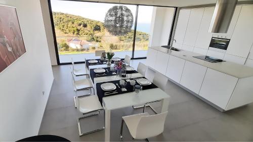 a kitchen with white cabinets and a table and chairs at Villa Pescaria in Nazaré