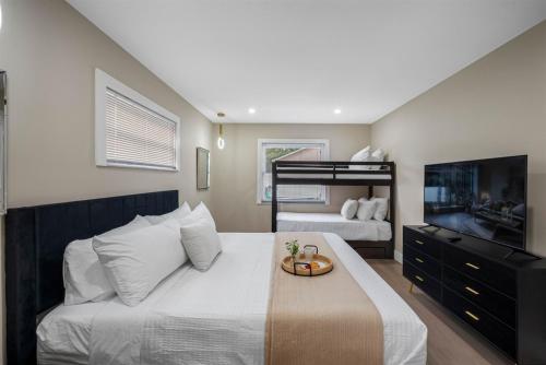 a bedroom with a bed and a tv and a bunk bed at Luxe Getaway w Pool, Games & Fun Vibes in Palm Harbor