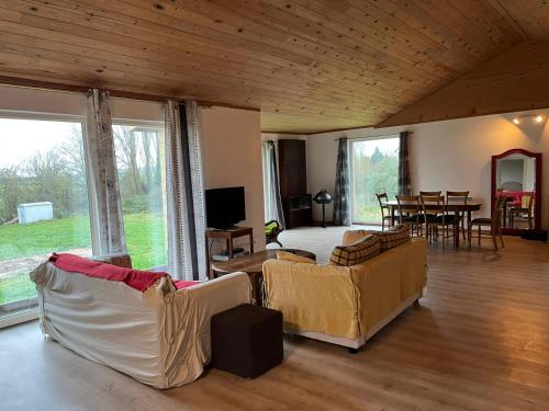 Sala de estar con sofás, cama y mesa en Le Saint-Germain - Maison en bois en pleine nature, en Saint-Germain-Chassenay