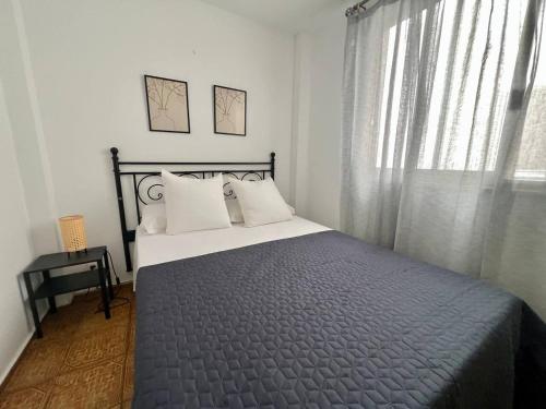 ein Schlafzimmer mit einem Bett und einem Fenster in der Unterkunft De La Torre 1 in Guanarteme