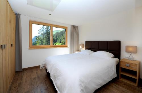 シュレッケンにあるAppartement Rothornblickのベッドルーム(大きな白いベッド1台、窓付)