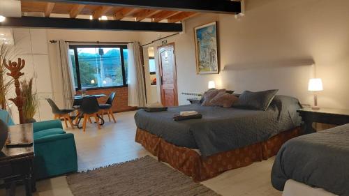 Un dormitorio con una cama grande y una mesa y sillas. en ARWEN Suites 1, en Trevelín