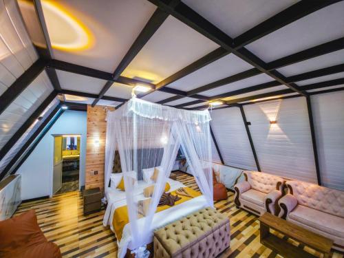 a bedroom with a bed and a couch in a room at White Moon Cabin & Cottage in Ella