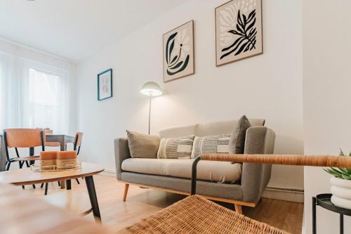 a living room with a couch and a table at Les Jardins, T3 avec parking -2 voitures, 8min à pied de la gare in Lens