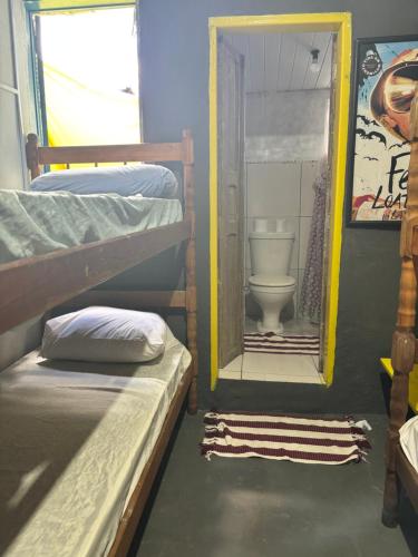 a room with a bathroom with a toilet and a mirror at Casa Lee Hostel in Paraty