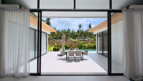 een eetkamer met een tafel en stoelen bij White Lotus Villa in Ban Madua Wan