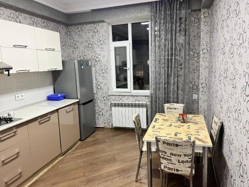 a kitchen with a table with chairs and a refrigerator at Apartment city in Baku