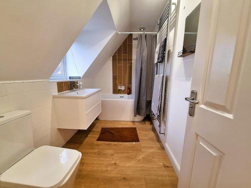 a bathroom with a white toilet and a sink at Modern home close to amenities and transport links in Wymondham