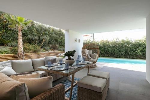 a living room with a couch and chairs and a pool at Ocean & Pool Retreat Villa by HostWise in Amoreira
