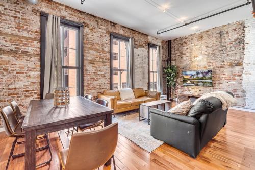 a living room with a brick wall and a table and chairs at The Founders Suite Residence in Philadelphia