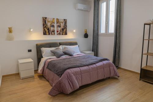 een slaapkamer met een bed met een schilderij aan de muur bij LIONS ROOMS Augusta in Augusta