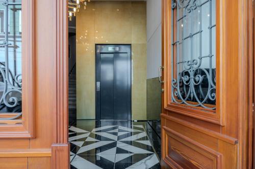 a hallway with a door and a tile floor at Palazzo Machiavelli Trieste in Trieste