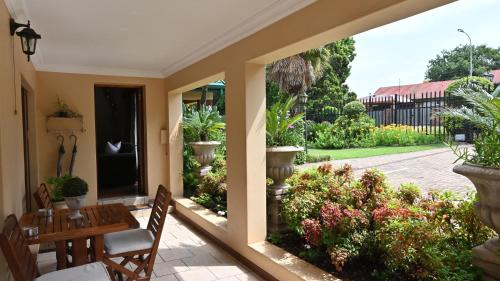 LUXURY ROOM @ 4 STAR GUEST HOUSE في ميدلبرغ: فناء مع طاولة وكراسي والنباتات