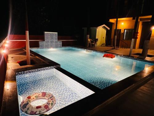 a swimming pool at night with a bowl in it at Deepdaya Cottage in Alibag