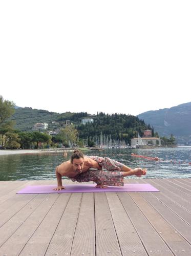 a man doing a push up on a mat by the water at Hotel Gabry in Riva del Garda