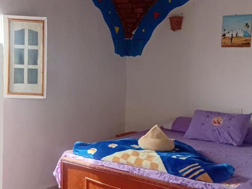 a bedroom with a bed with a blue comforter at Wesy Ka Guest House in Aswan