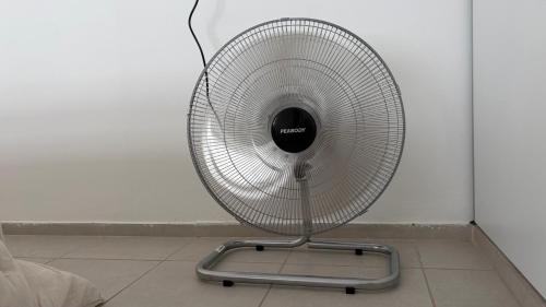 a white fan sitting on a floor next to a wall at Temporario Sur, hasta 4 personas con 3 camas, General Roca in General Roca