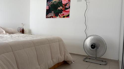 a bedroom with a fan next to a bed at Temporario Sur, hasta 4 personas con 3 camas, General Roca in General Roca