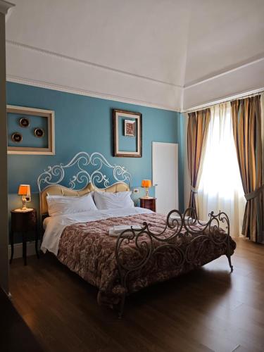 a bedroom with a large bed with blue walls at Dimora Antica Pianella in Pianella
