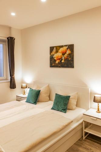 a bedroom with a large bed with green pillows at CityPension-Vreden in Vreden