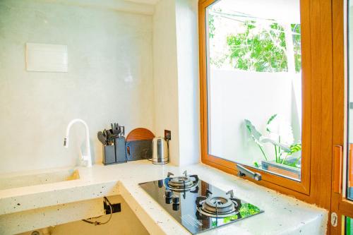 een keuken met een fornuis en een raam bij Bahari View in Jambiani