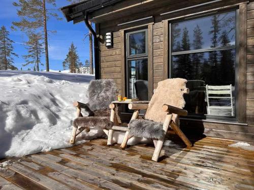 a cat sitting on a wooden deck in front of a cabin at TH2124- Spacious ski-in out cabin in Trysilfjell with 5 bedrooms in Hovi