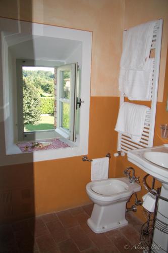 a bathroom with a toilet and a sink and a window at La Casatorre Di Ponticello in Filattiera