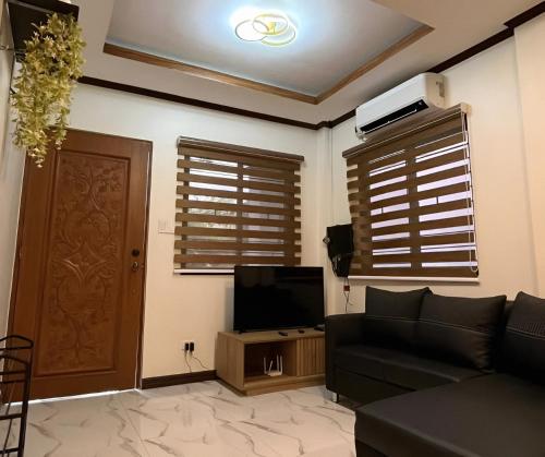 uma sala de estar com um sofá e uma televisão em Ranch-o-tel Guesthouse em Sampong