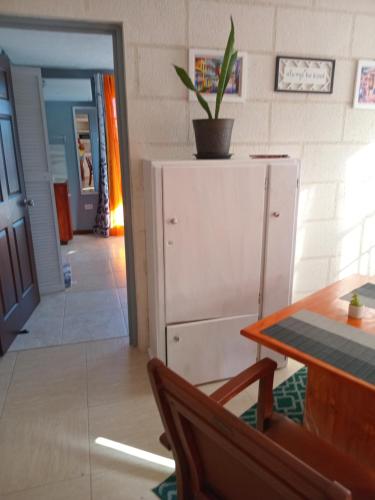 a room with a table and a cabinet with a plant on it at Love Den in Christ Church