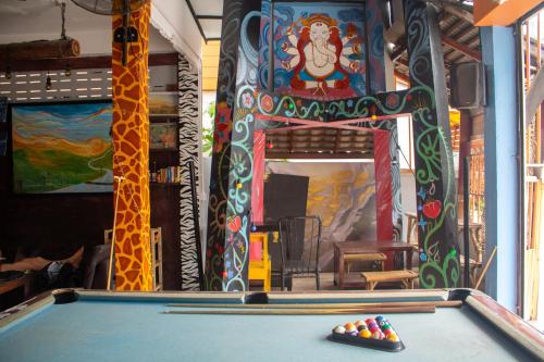a pool table in a room with a giraffe painting at Revolution Pai In Town in Pai