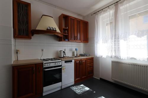 a kitchen with wooden cabinets and a stove and a window at Dom na wyłączność #Beskidzka FV PARKING IMPREZY dozwolone in Rzeszów