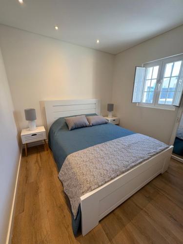 une chambre avec un grand lit et deux tables de nuit dans l'établissement Casa das Orquídeas Meco, à Sesimbra