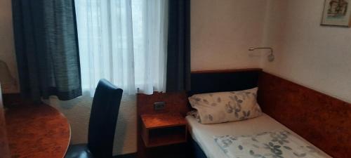 a small bedroom with a bed and a window at Hotel Corveyer Hof in Höxter