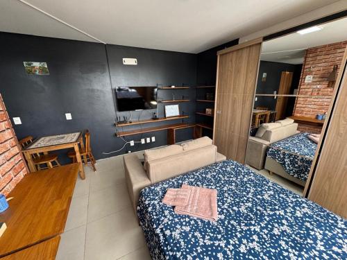 Fit Residence في بينتو جونكالفيس: غرفة نوم بها سرير وأريكة وتلفزيون