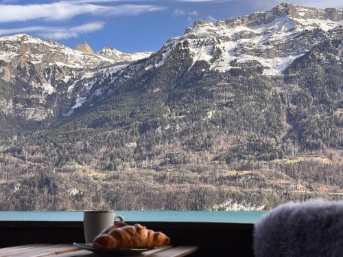 a table with a plate of bread and a mountain at Breathtaking Lake & Mountain View Apartment 2 in Niederried