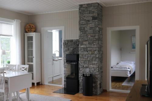 een woonkamer met een stenen open haard en een slaapkamer bij Cabin in Mestervik in Meistervik