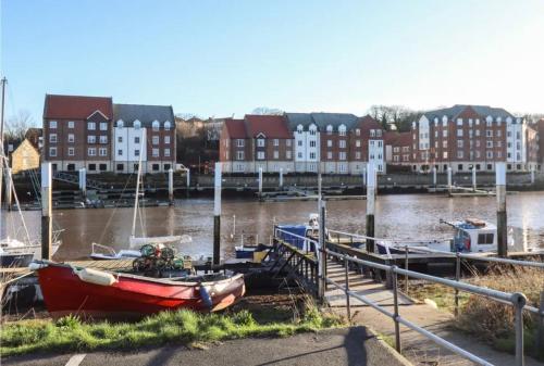 un bateau est amarré dans un port de plaisance avec des bâtiments dans l'établissement Majestic, modern & spacious harbour-view apartment with parking, à Whitby