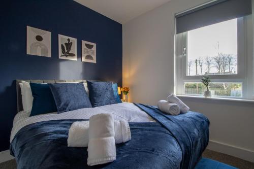 En eller flere senge i et værelse på The Wishy - 2 Bedroom Flat in Newmains