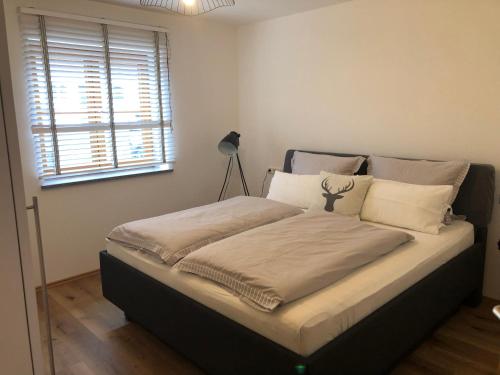 een groot bed in een kamer met een raam bij FreiRaum in Ofterschwang
