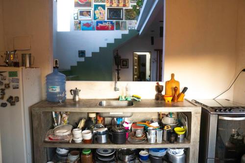 una cucina con un lavello e uno scaffale con pentole e padelle di Casa Anéis de Saturno a Pipa